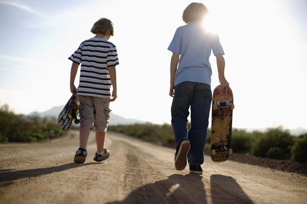 男孩在公路上滑板 男孩在公路上滑板